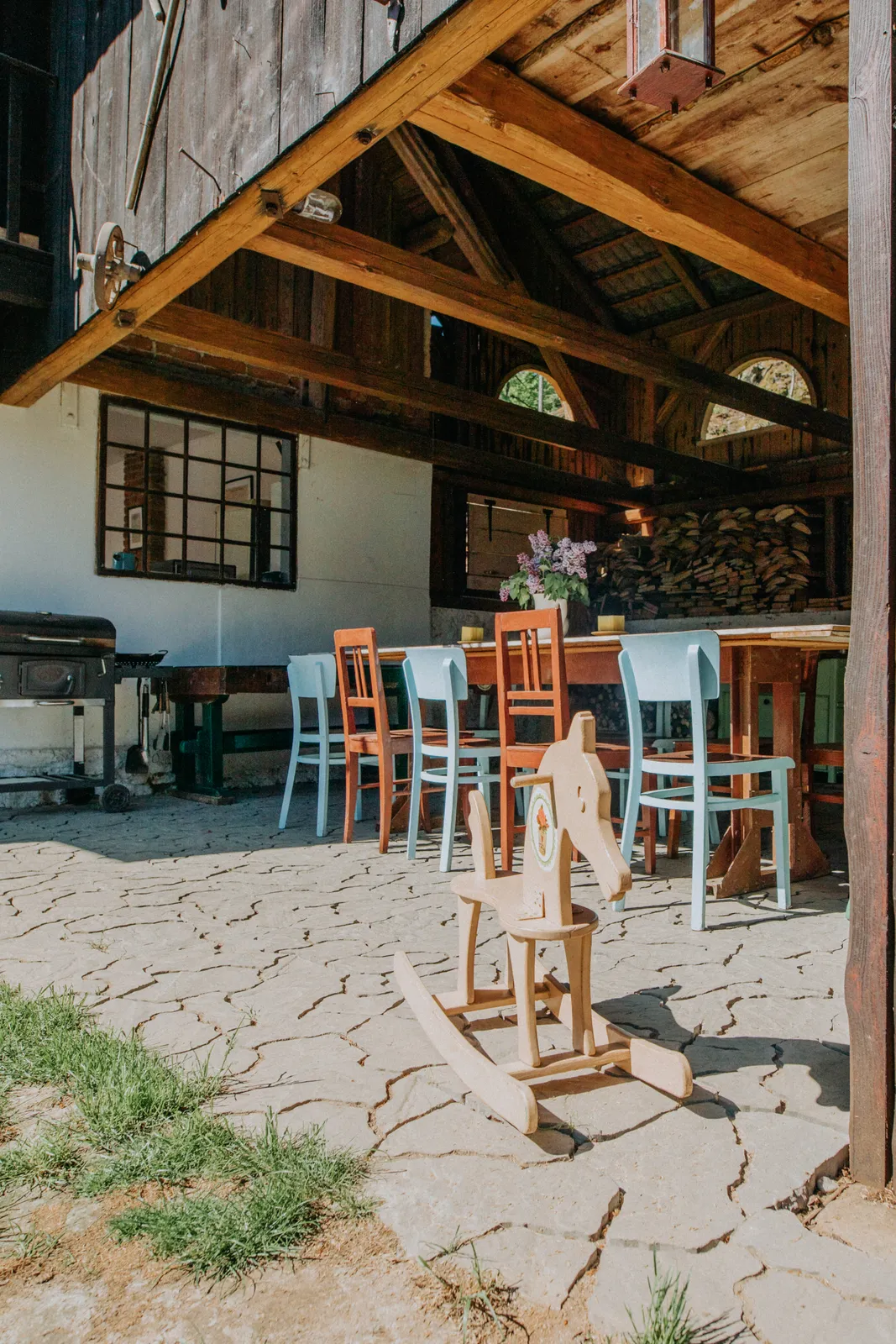 Kryté posezení a dětský koutek s houpacím koníkem u stodoly